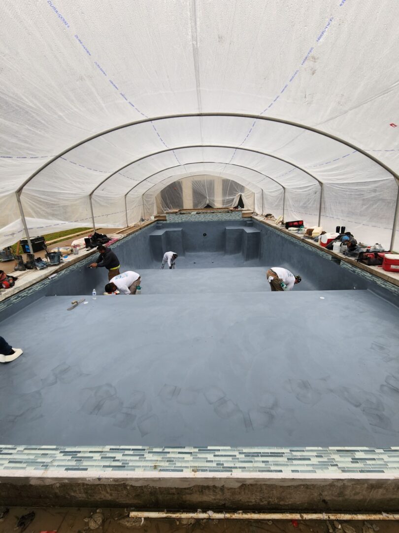 A group of people laying around in an indoor swimming pool.